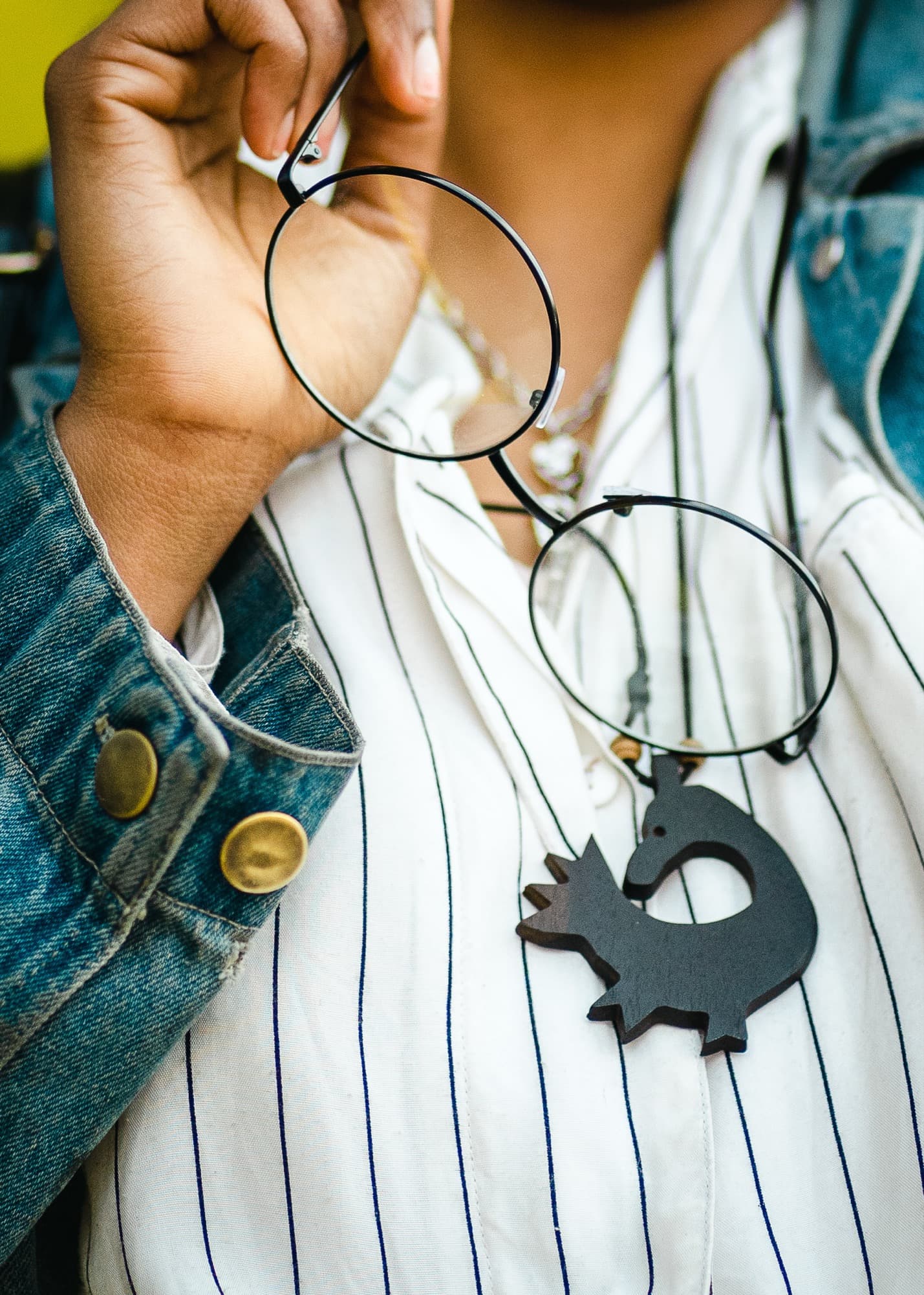 Detail shot of a model holding round glasses